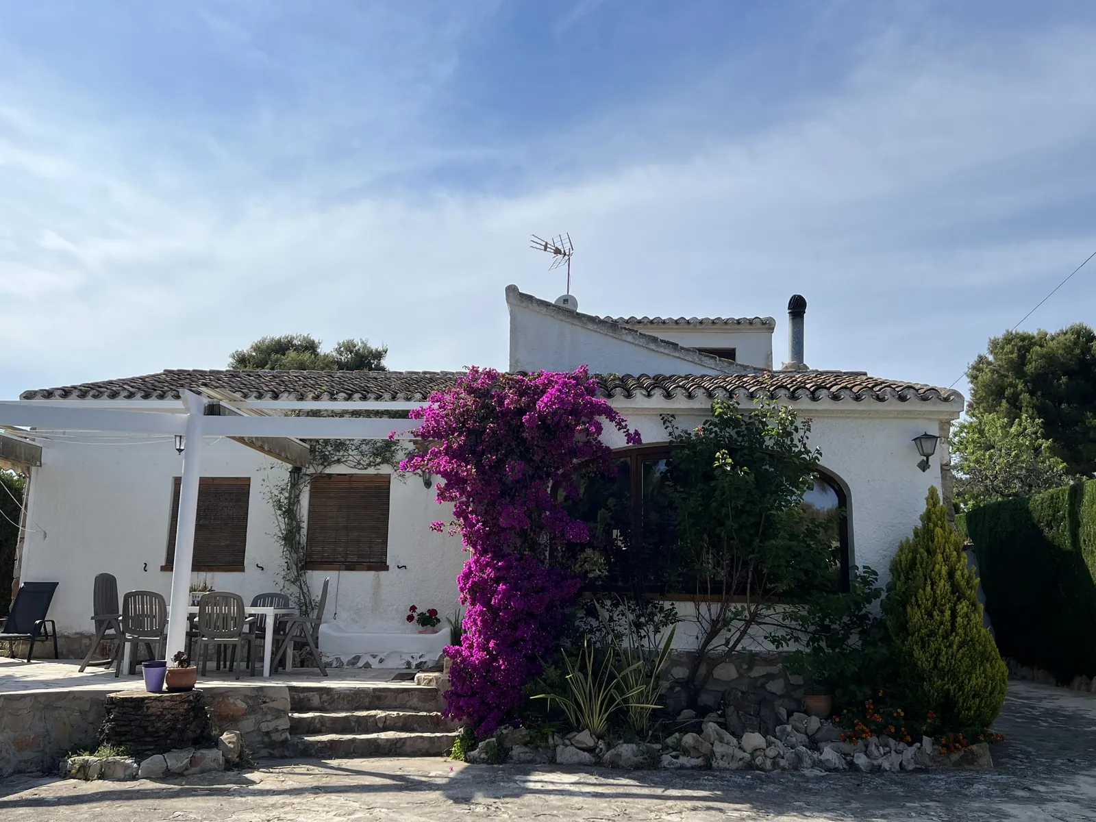Fachada frontal de Casa Els Molins con terraza y buganvilla